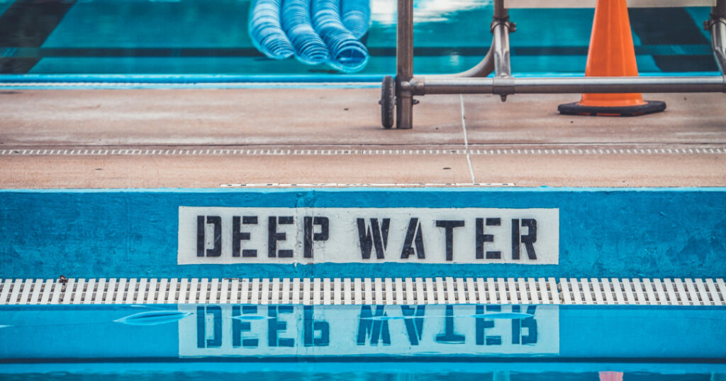 Collard Spiritual Direction * Spiritual life is living in the deep end * Photo of the words "deep water" in a swimming pool by Rosie Kerr via Unsplash