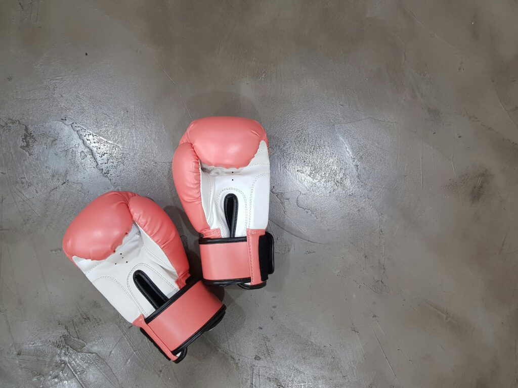 Collard Spiritual Direction. A pair of pink boxing gloves on a concrete floor.  Arisa-chattasa via Unsplash